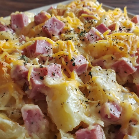 A close up of a cheesy ham potato casserole.