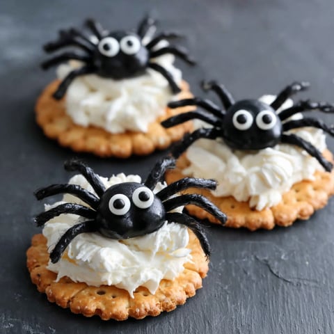 Three black spider crackers with white frosting.