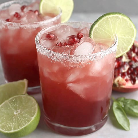 Two glasses of a tangy pomegranate margarita mocktail.