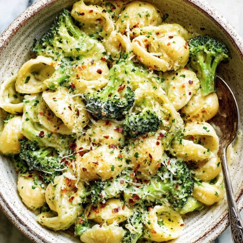 A bowl of mac and cheese with broccoli.