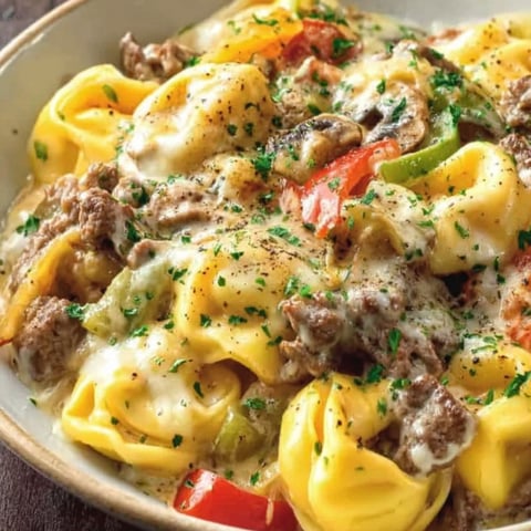 A bowl of food with cheese and tomatoes.