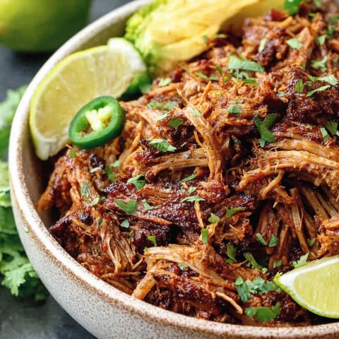 A bowl of beef with limes and broccoli.