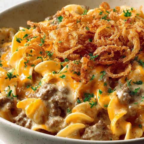 A bowl of beef and noodle casserole with crispy french onions.