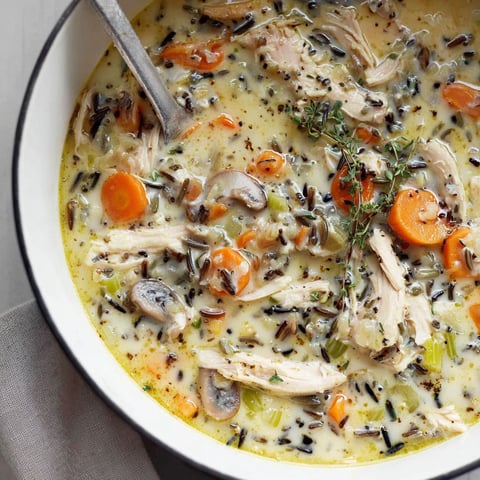 A bowl of soup with chicken and rice.