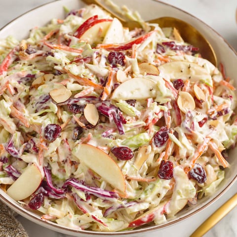 A bowl of apple slaw with red cabbage and apples.