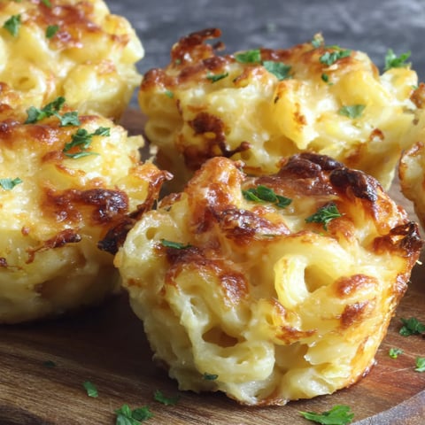Baked mac and cheese bites on a wooden cutting board.