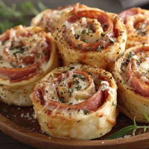 A plate of bacon wrapped tortilla rolls.
