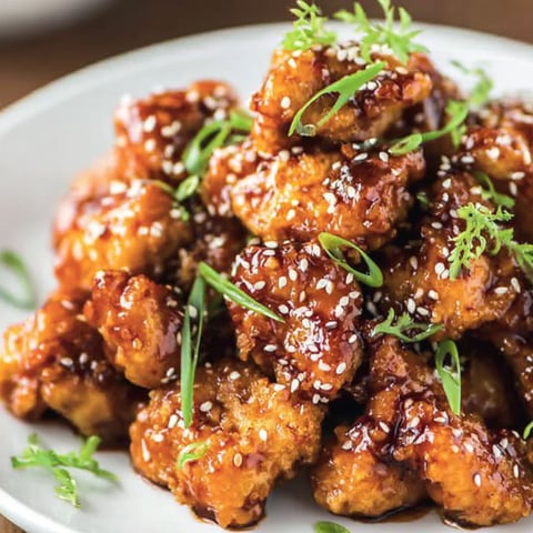 A plate of General Tso Chicken with sauce.