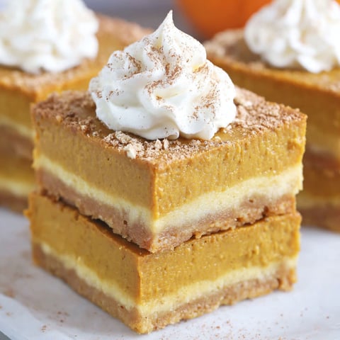 A slice of pumpkin pie bars with whipped cream on top.