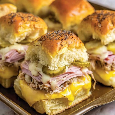 Cuban sliders with cheese and pickles.